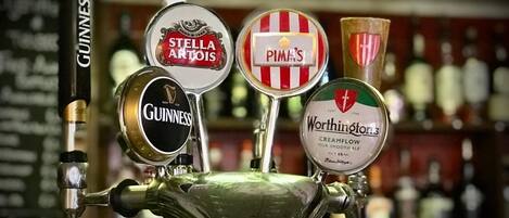 A bar tap with multiple beer taps including brands like Guinness, Stella Artois, Pima's, and Worthington's.