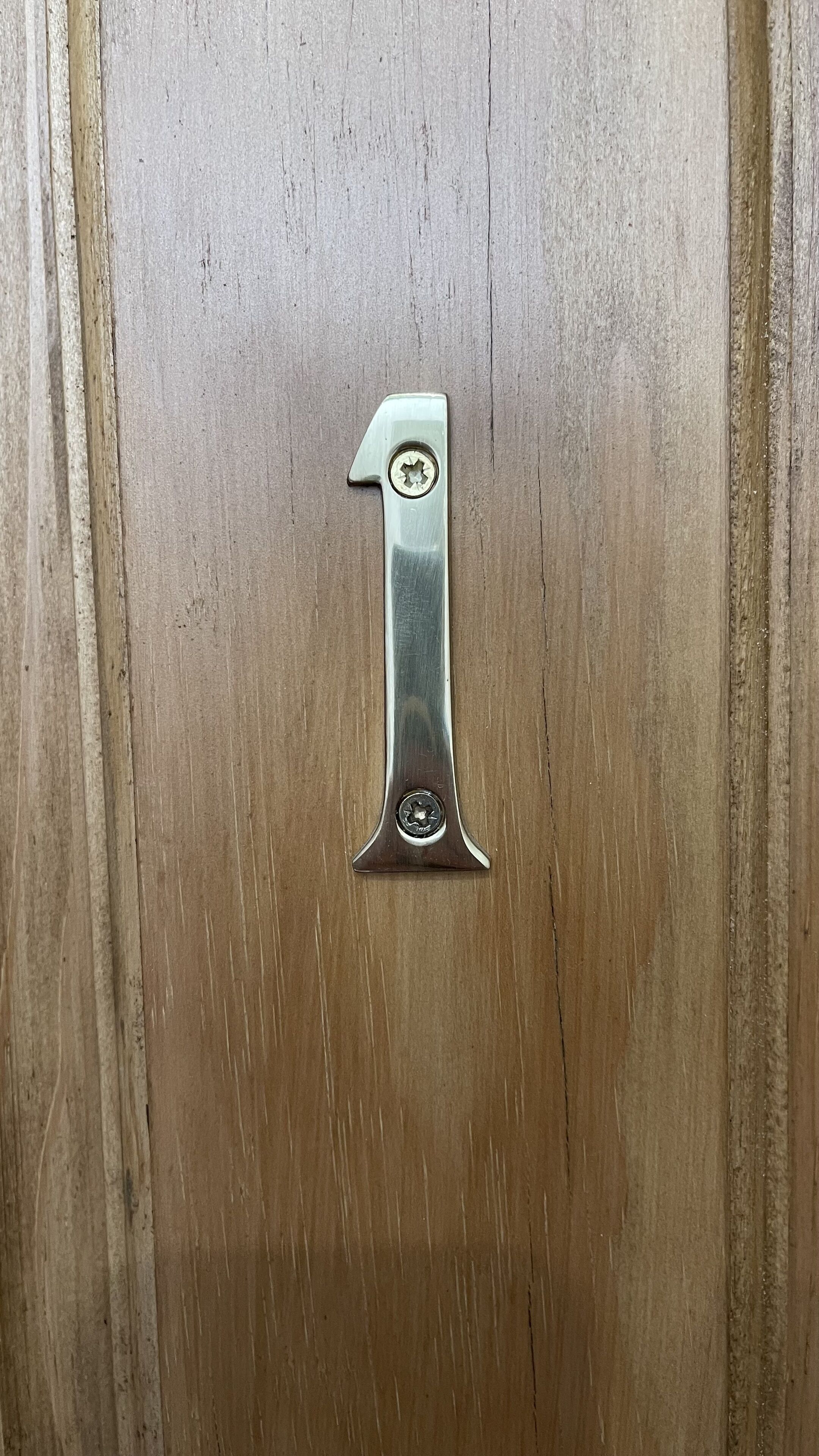 A wooden door with a metal number 1 handle.