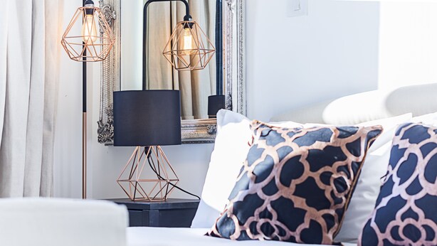 A neatly arranged hotel room with a bed, a bedside table, a lamp, and a mirror. - Deluxe Kensington Apartment With Balcony (London)