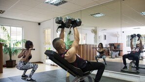A gym with exercise equipment and mirrors. - Hotel North Resort (Paramaribo)