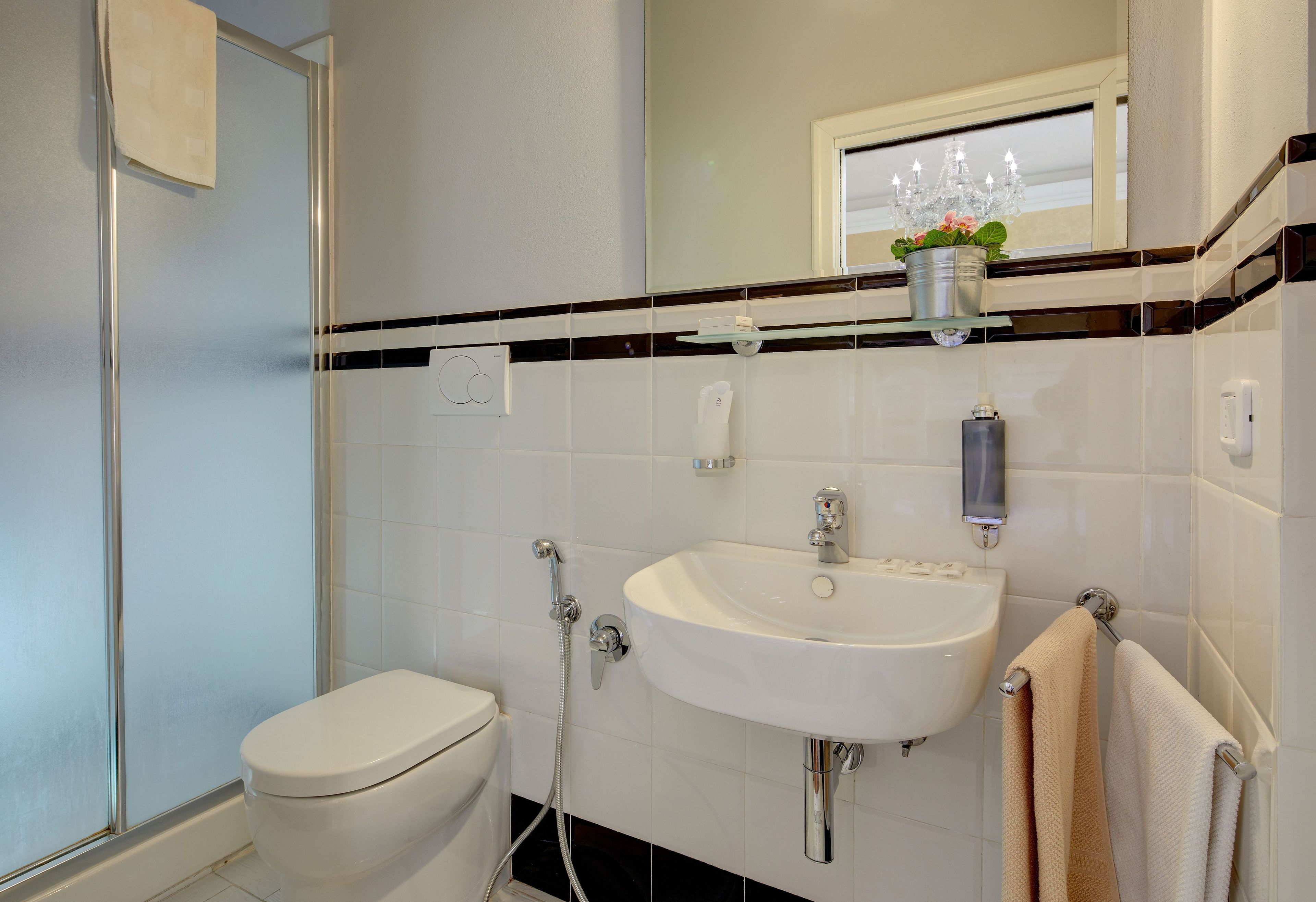 Une salle de bain avec des toilettes, un lavabo et une douche.