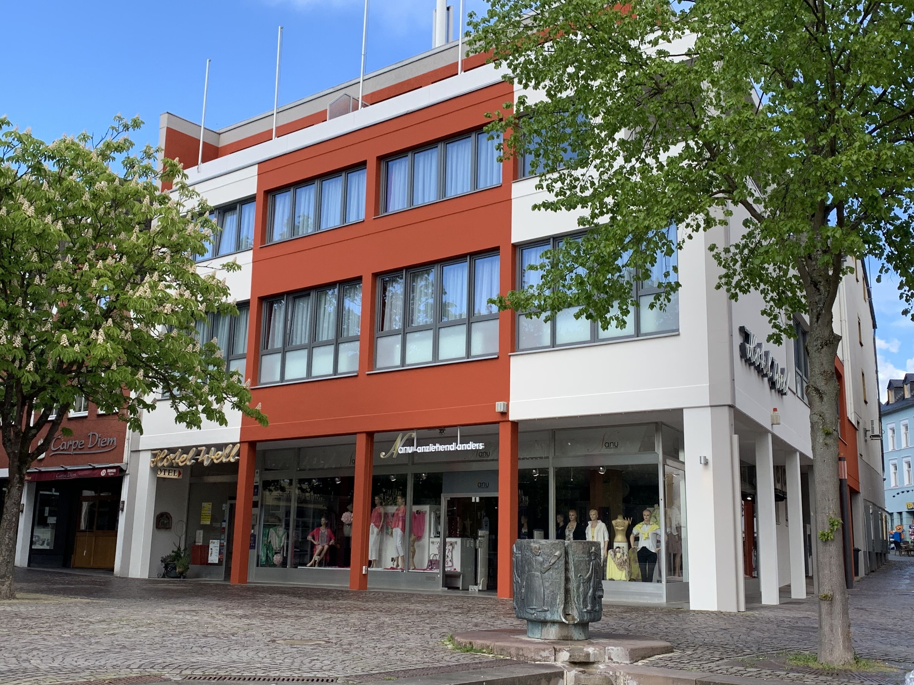 Een modern gebouw met een winkel op de begane grond en appartementen op de bovenverdiepingen.