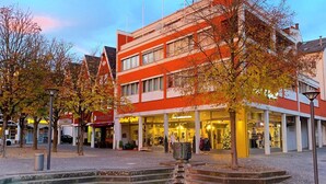 A building with a modern architectural style, featuring a courtyard with a reflective water feature and steps leading up to it. - Hotel Well Garni (Wittlich)