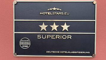 Una placa con una calificación de cuatro estrellas, el logotipo de HotelStars.eu y el texto 'DEUTSCHE HOTELKLASSIFIZIERUNG'.
