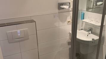 Ein modernes Badezimmer mit Toilette, einer Duschkabine aus Glas und einem Waschbecken.
