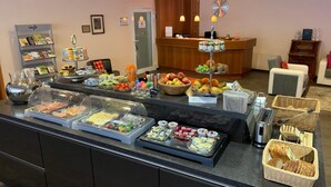 A buffet area with various food items and a reception desk in the background. - Hotel Well Garni (Wittlich)