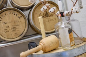 Toneles de madera con inscripciones, un rodillo y una botella con etiqueta.
