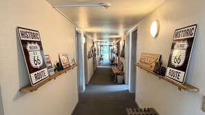 A hallway with two signs labeled 'Historic Route 66' on either side, a bench in the center, and a light fixture on the ceiling. - Knaplund Destillery (Tarm)