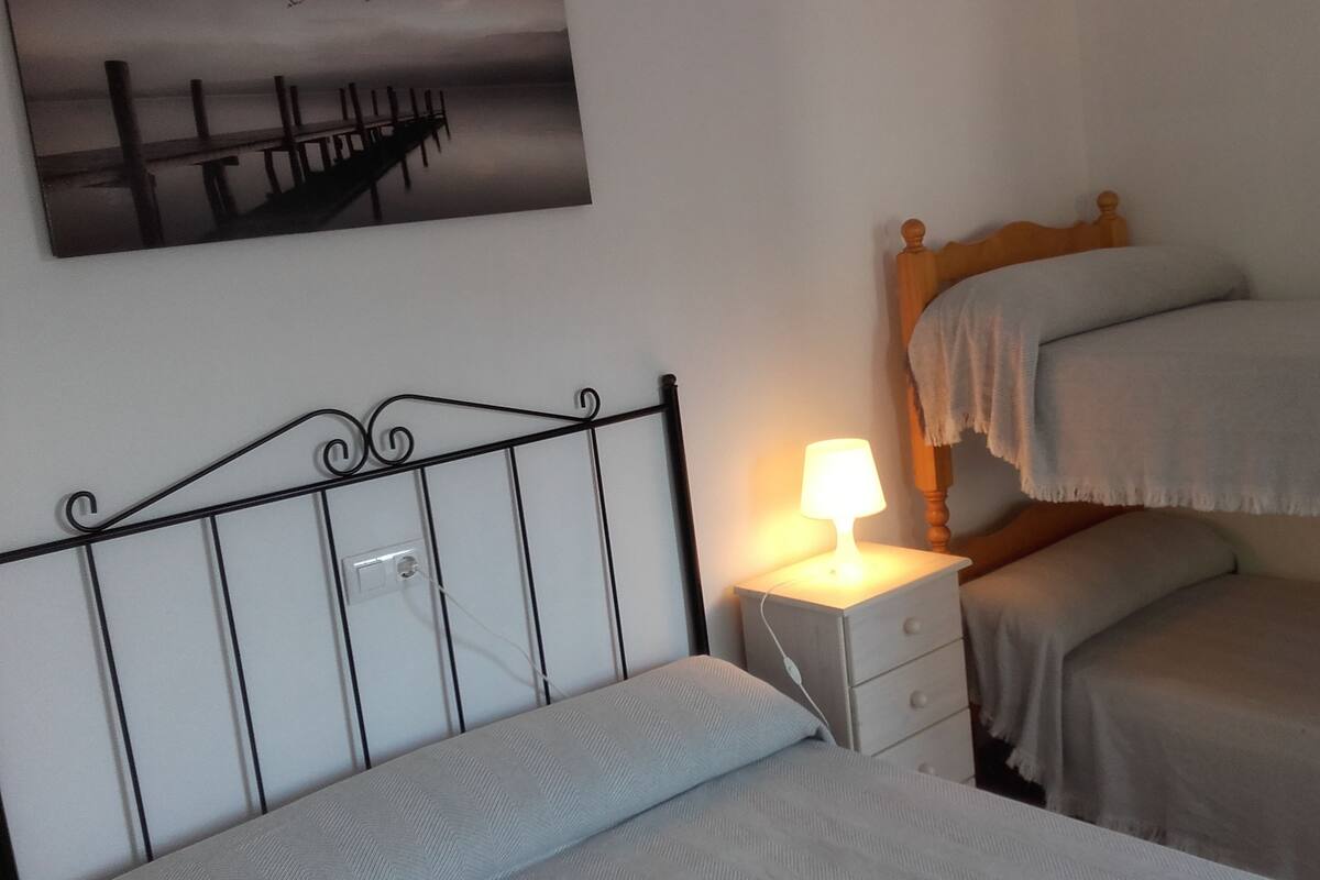 Une chambre à coucher avec un lit, une table de chevet, une lampe et un tableau au mur.