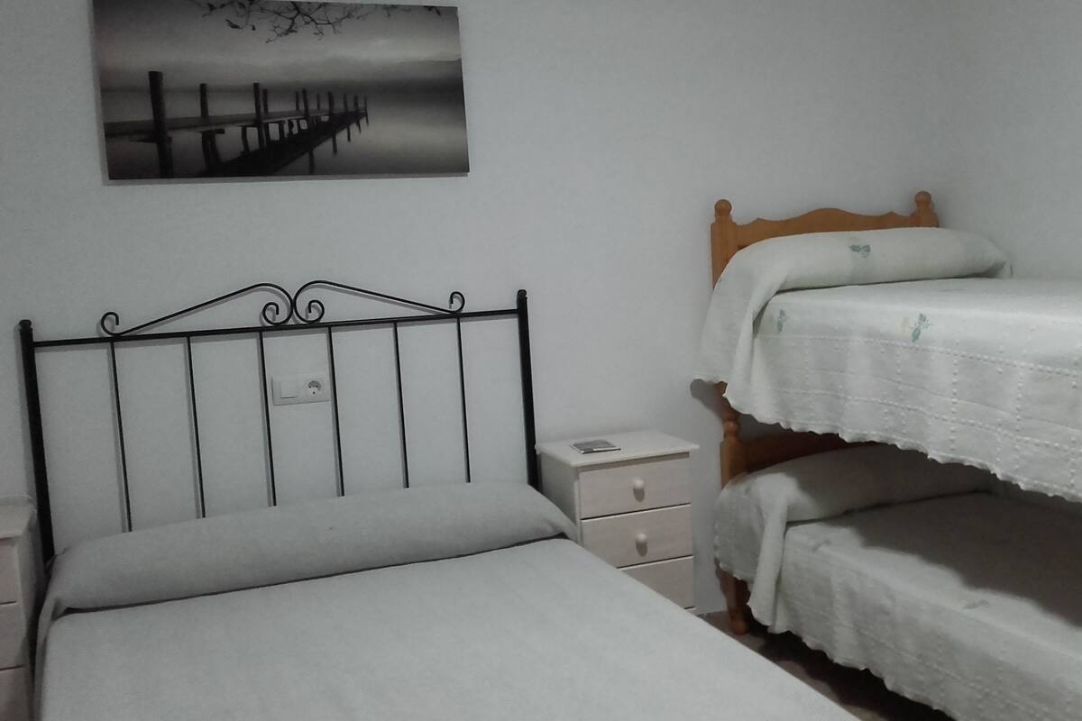 Une chambre à coucher avec un lit simple, une table de chevet et une tête de lit en bois.