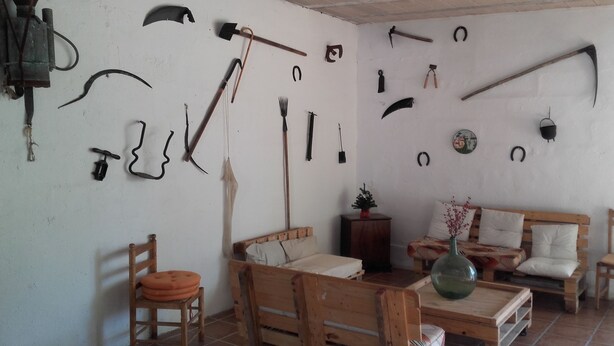 A room with a wooden sofa, a chair, and a small table. - La Llar de Laura (Amposta)
