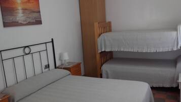 Une chambre avec deux lits, une table de chevet, une lampe et un tableau au mur.