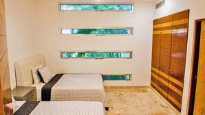 Un dormitorio con dos camas, ventilador de techo y armario.