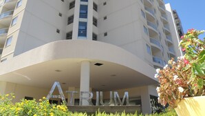A high-rise building with the name 'ATRIUM' prominently displayed on its facade. - Atrium - Achei Ferias (Caldas Novas)