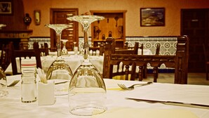 A restaurant interior with tables set for dining, featuring clear glassware and cutlery.