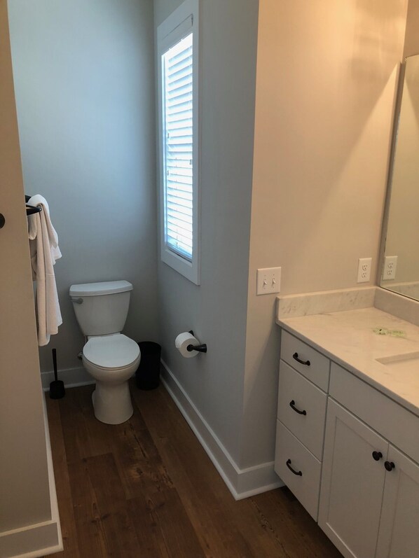 A bathroom with a toilet, a sink, and a mirror.
