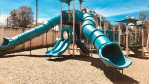 A playground with multiple slides and a climbing structure. - Milimani Serviced Apartments (Nakuru)