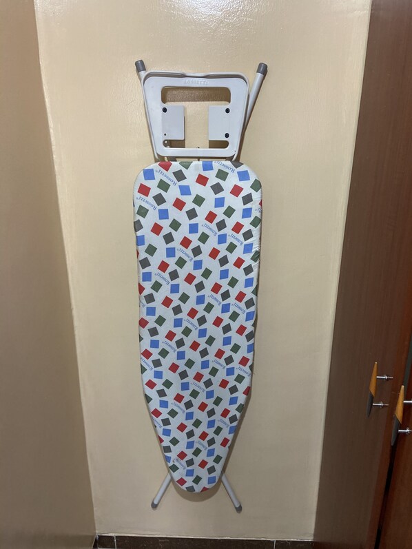 A wall-mounted ironing board with a patterned ironing board cover.