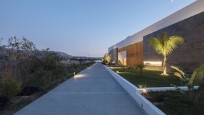 A pathway leading to a building with a modern design, surrounded by greenery and a clear sky. - D Andrea Lagoon All Suites - Adults only (Kos)