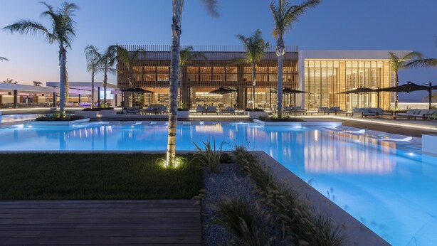 A modern hotel with a swimming pool, palm trees, and lounge areas. - D Andrea Lagoon All Suites - Adults only (Kos)