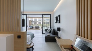 A modern, well-lit bedroom with a large window, a sofa, a desk, and a bed. - D Andrea Lagoon All Suites - Adults only (Kos)