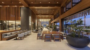 A spacious indoor area with multiple seating arrangements, a large potted plant, and a view of the outdoors. - D Andrea Lagoon All Suites - Adults only (Kos)