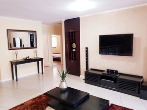 Departamento de lujo, 3 habitaciones, vista al canal, planta baja | Área de sala de estar | Televisión de pantalla plana y consola de videojuegos 