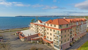 A multi-story hotel with balconies, a parking lot, and a view of the water. - WorldMark Blaine (Blaine)
