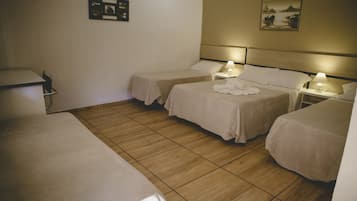 Een hotelkamer met twee eenpersoonsbedden, een bureau en een stoel. Er zijn wandlampen en een ingelijst kunstwerk aan de muur.
