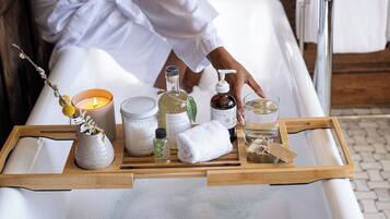 A tray with various toiletries and a candle on a bed.
