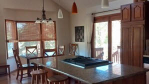 A kitchen with a central island, wooden stools, and pendant lighting. - In town home- above the 1880 train.  Walk to Main St!— recently updated! (Hill City)