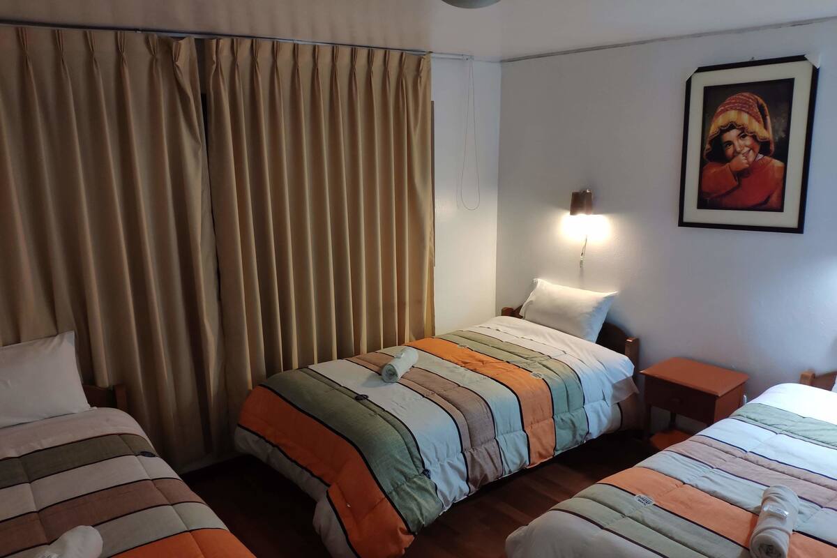 Ein Hotelzimmer mit zwei Betten, einem Nachttisch, einer Lampe und einem Bild an der Wand.