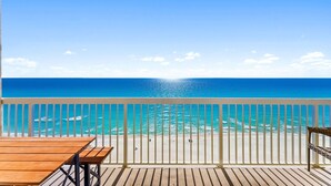 Une terrasse en bois avec une balustrade blanche donnant sur une plage.