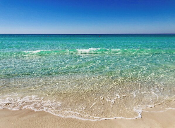 A beach with clear turquoise water and gentle waves.