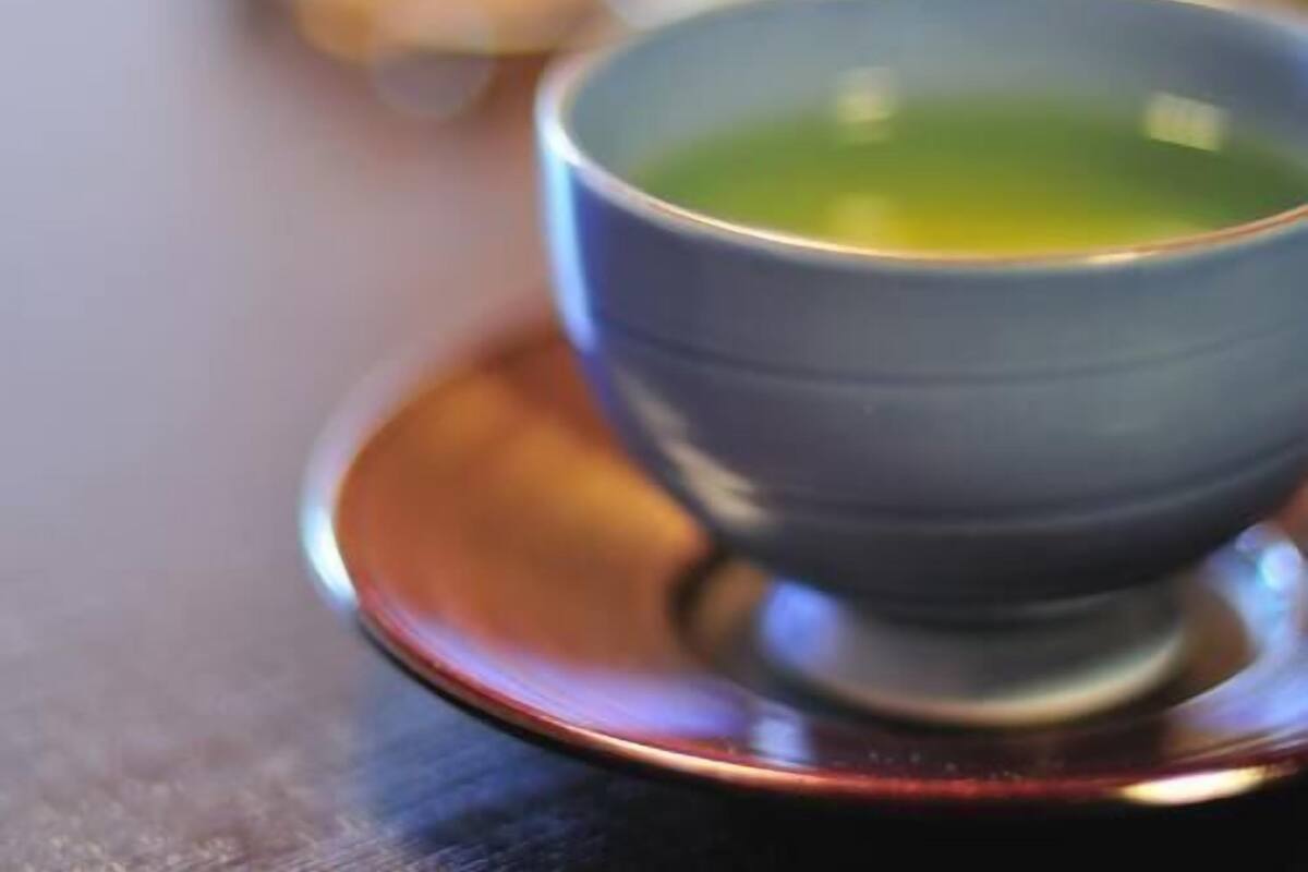 A bowl of green tea on a saucer.