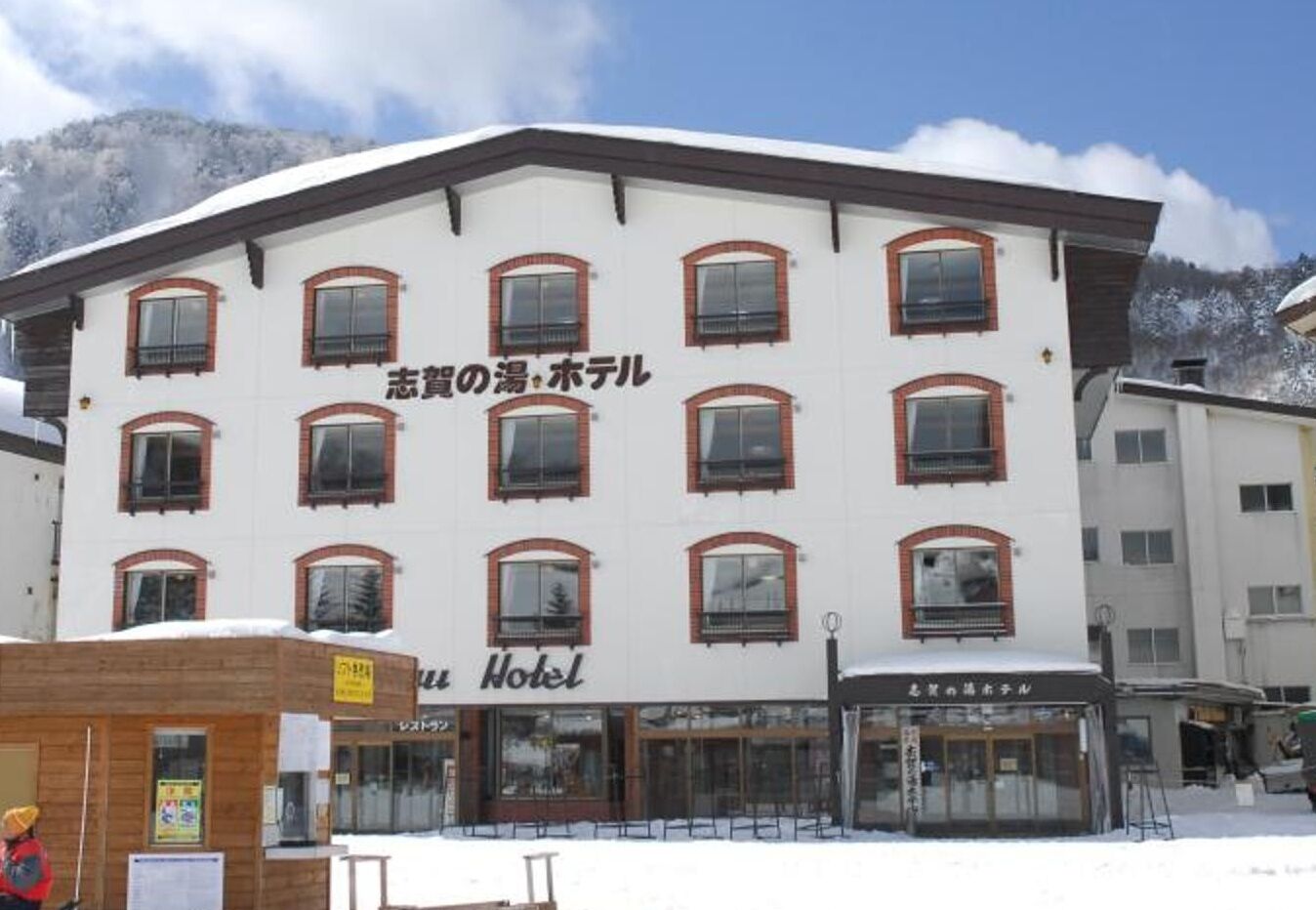 Un hôtel à la façade blanche, doté de nombreuses fenêtres et d’une enseigne indiquant le mot « Hôtel ».