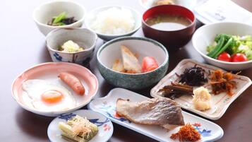 A variety of Japanese dishes including sushi, sashimi, and a bowl of soup.