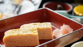 A rectangular red plate with two square pieces of food and a small amount of pinkish substance.