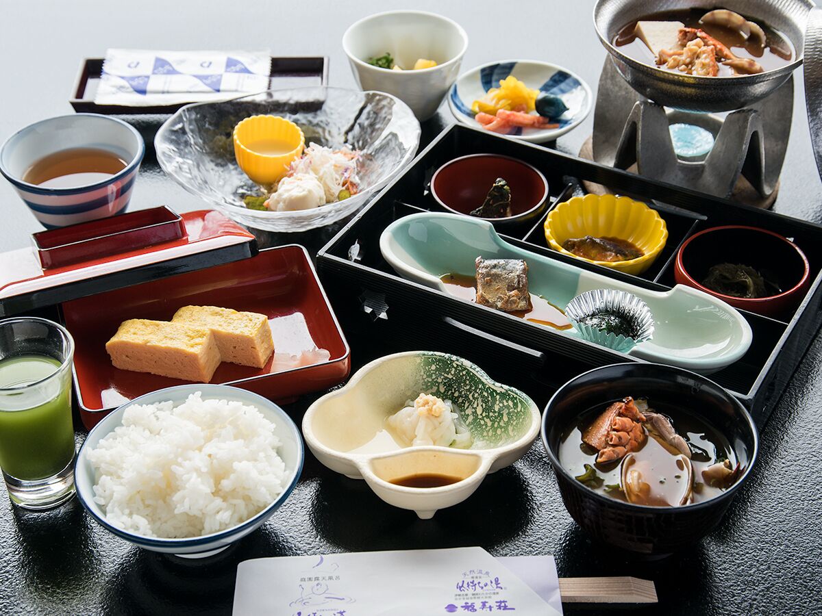 Een traditionele Japanse maaltijdopstelling met diverse gerechten en bestek.
