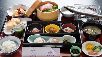 A traditional Japanese meal set on a wooden table with various dishes including rice, fish, and vegetables.