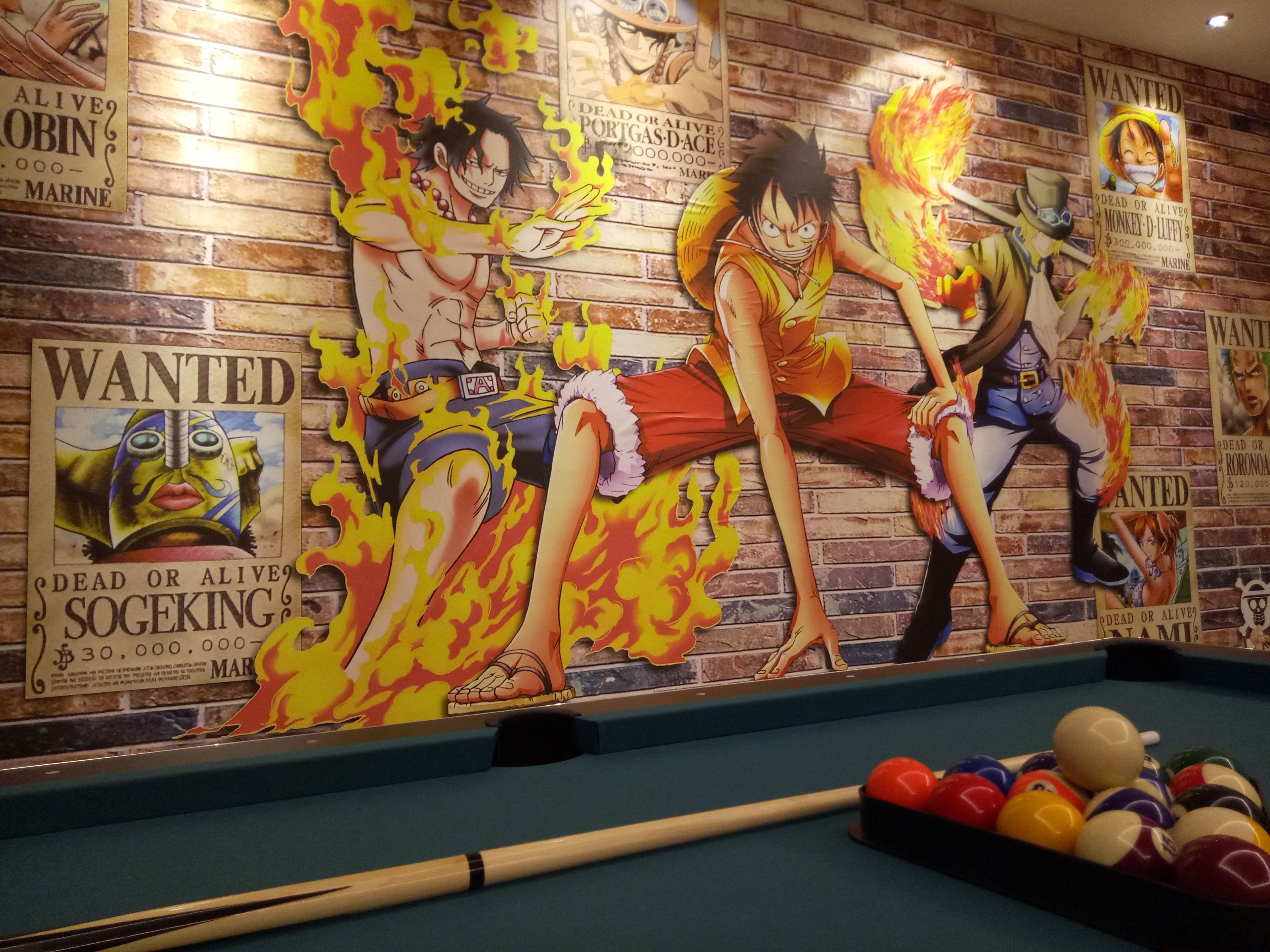 Una mesa de billar con un fondo de carteles de personajes de anime.