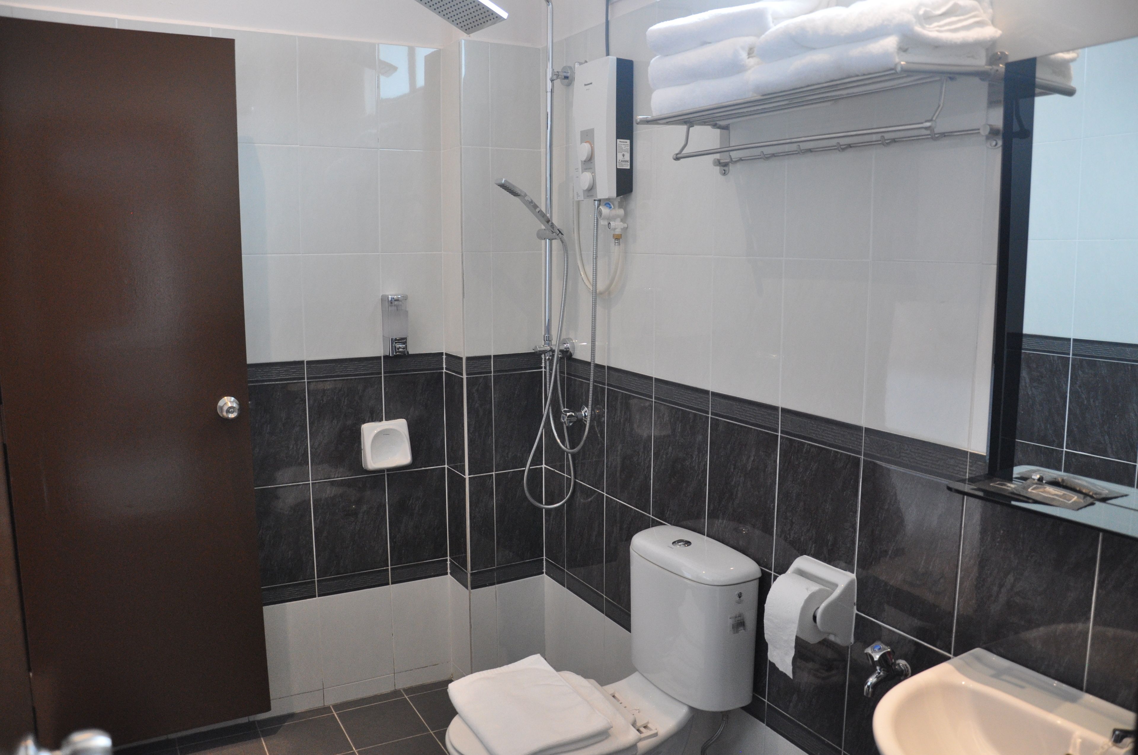 A bathroom with a toilet, bidet, sink, and towel rack.