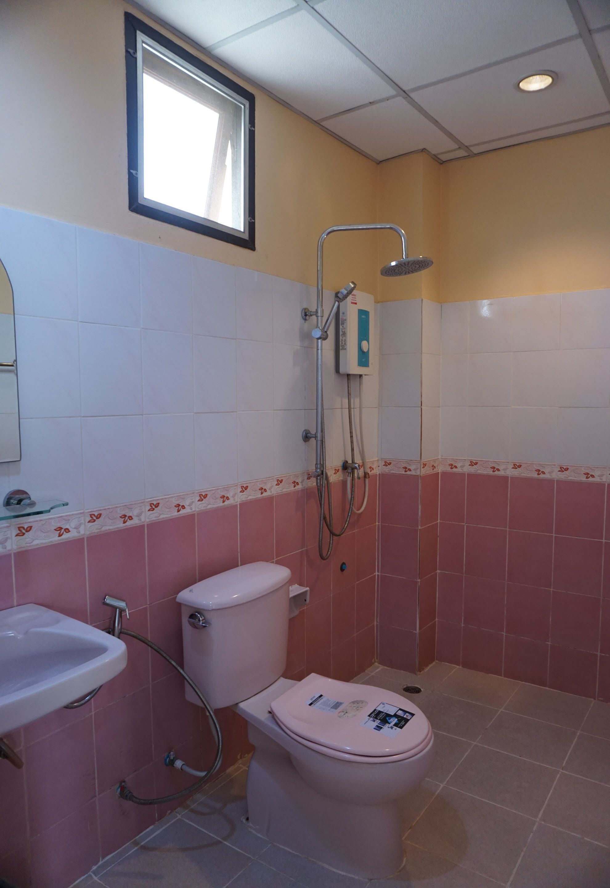 A bathroom with a toilet, sink, and shower.