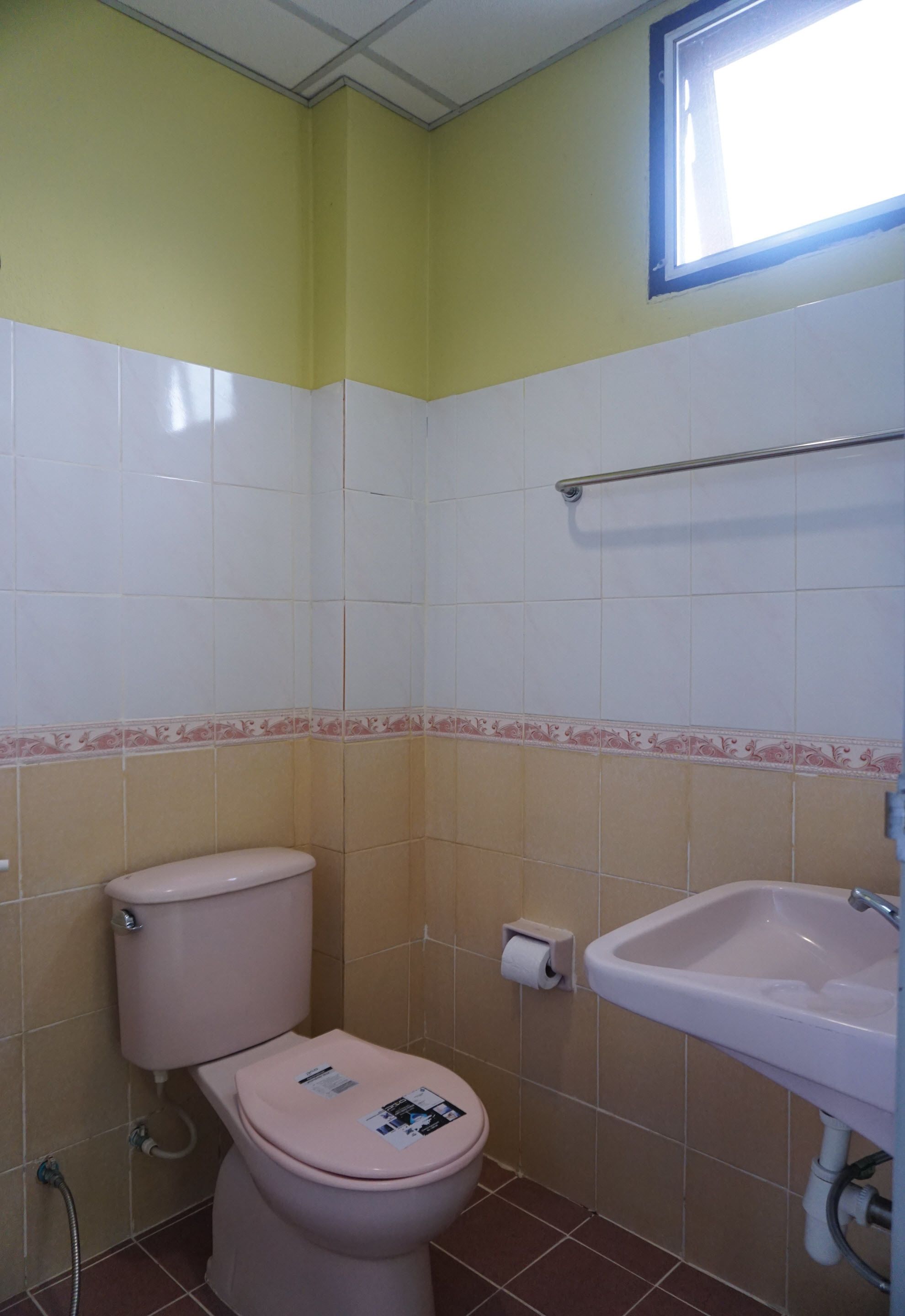 Un baño con inodoro, lavabo y ventana.