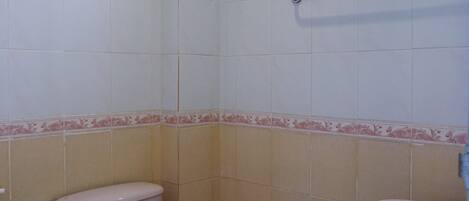 A bathroom with a toilet, sink, and a window.