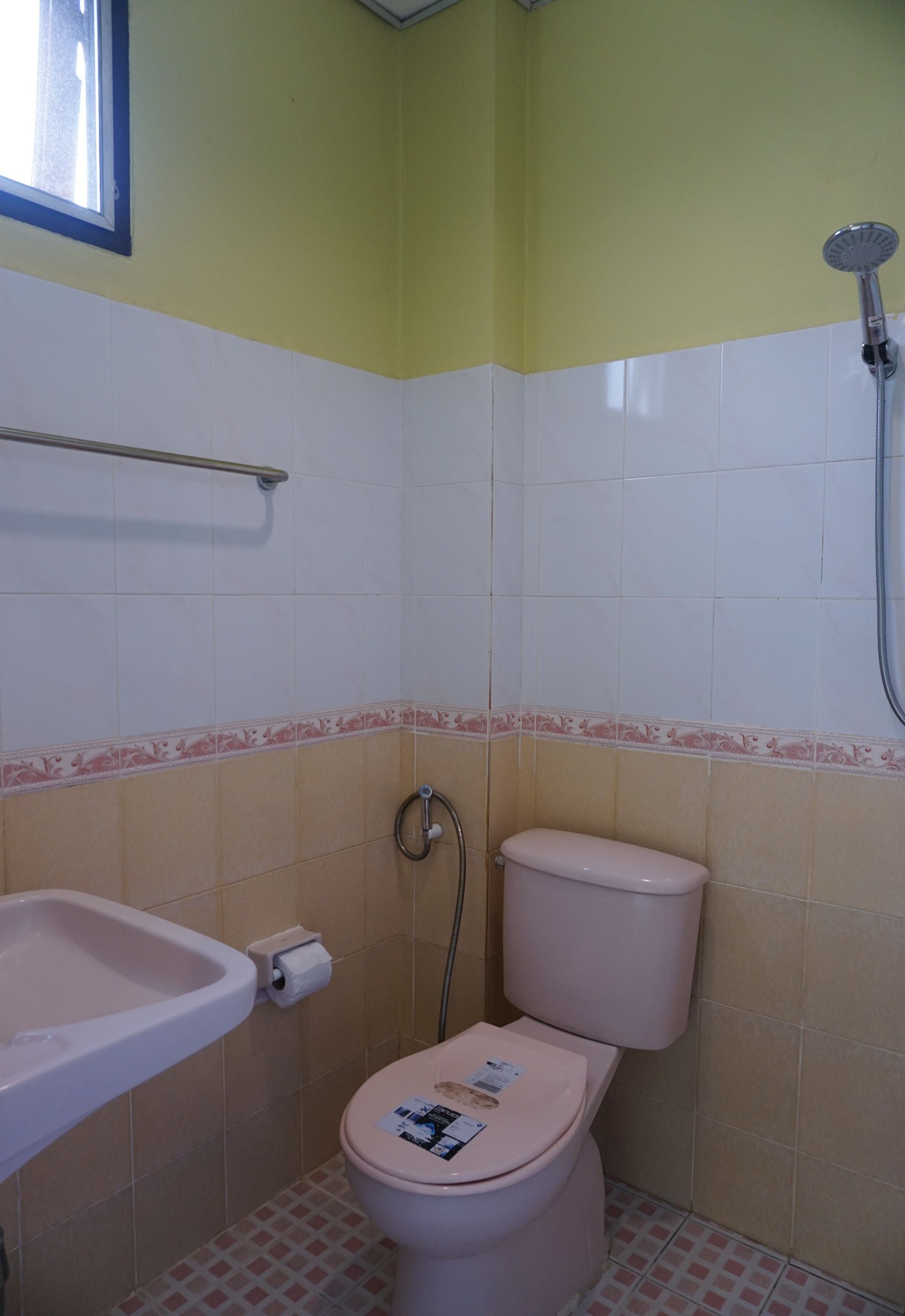 A small bathroom with a toilet, sink, and shower.