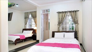 A hotel room with a large bed, a smaller bed, and a mirror. - Cosy House Homestay (Da Nang)