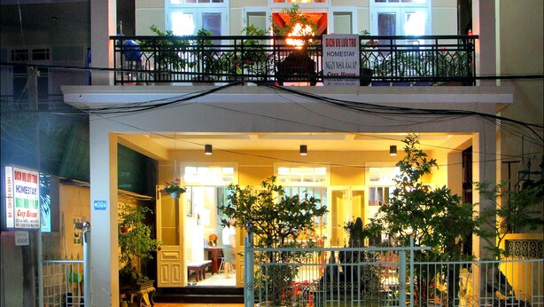 A two-story building with a balcony, a signboard, and a gated entrance. - Cosy House Homestay (Da Nang)