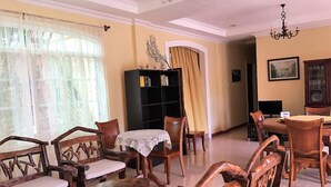 Comedor con muebles de madera, una araña y una estantería.