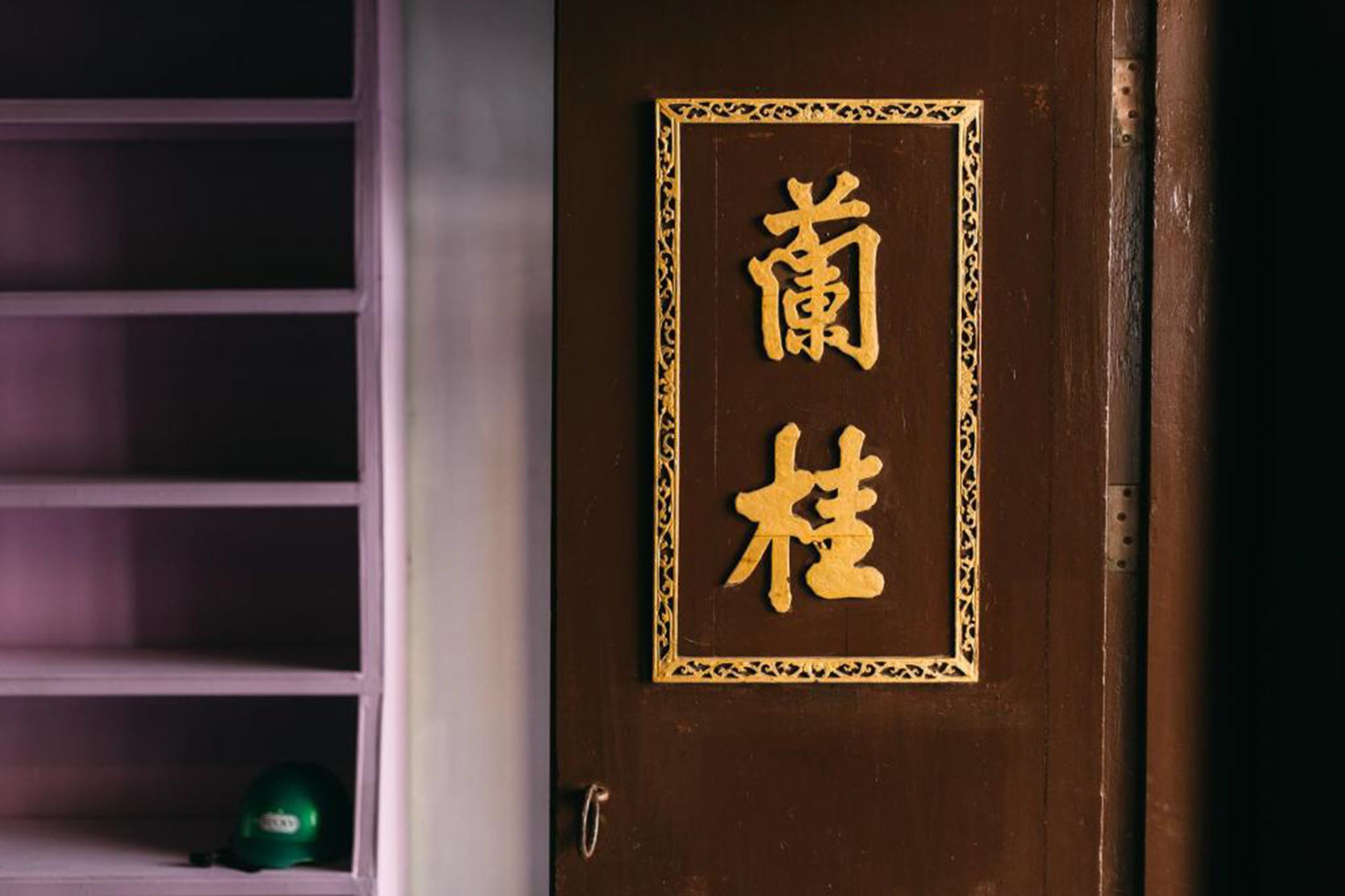 Una porta con cornice dorata e caratteri cinesi.